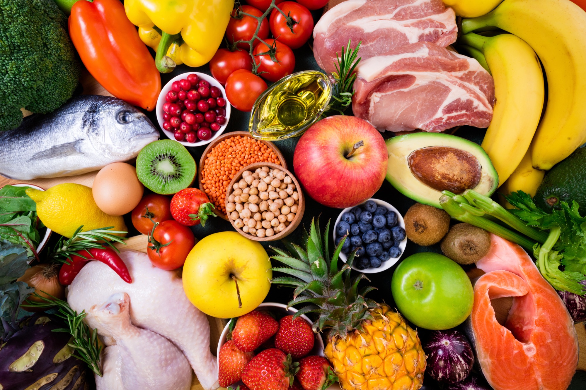 A vibrant spread of whole foods, fresh vegetables, fruit, fish, lean protein, and legumes